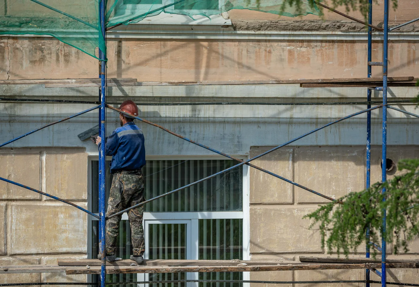 Arbeiten an einer Gebäudefassade mit Gerüst